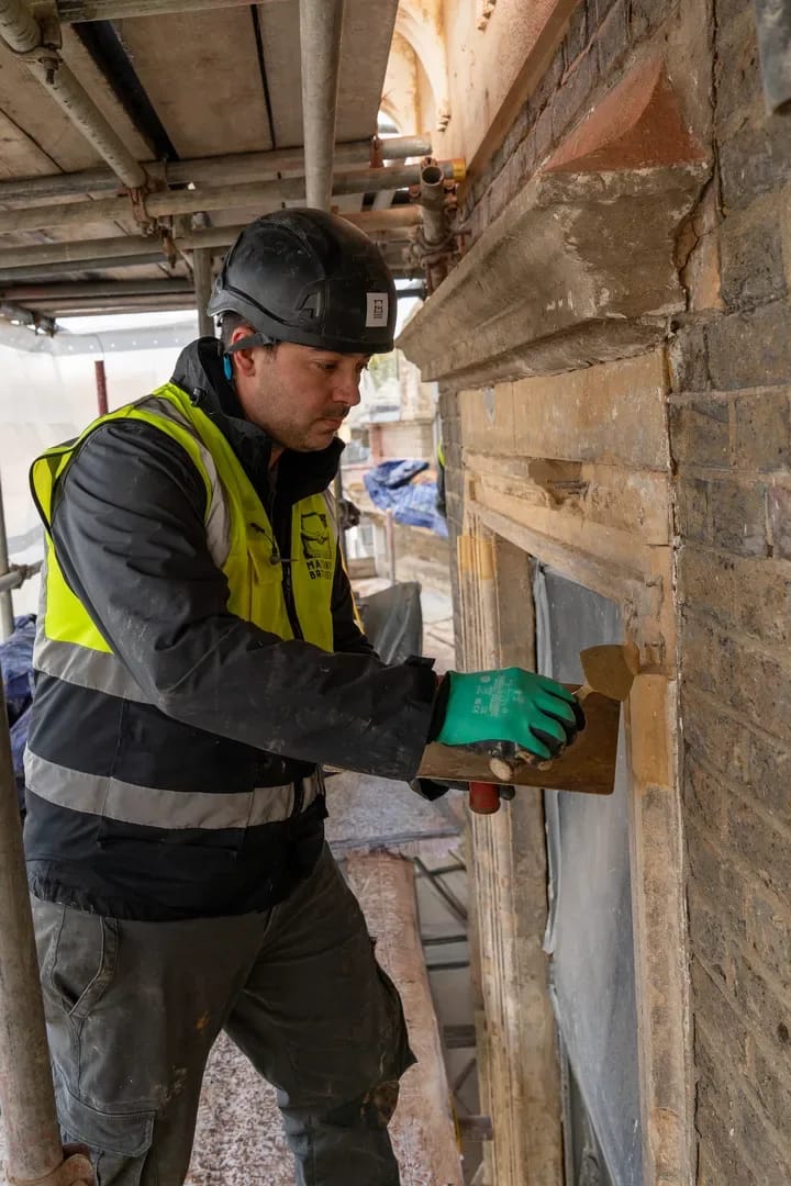 Worker repointing around a window surround
